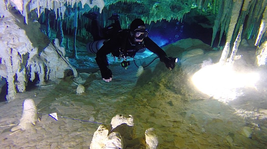 Technical diver running a line through an overhead cave